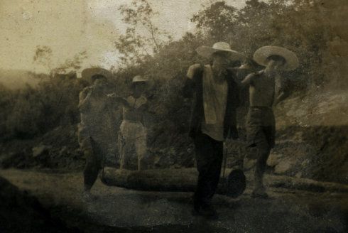 叔父（左一）他们4人将砍伐的树，从山林里抬到板车能行驶的山路边
